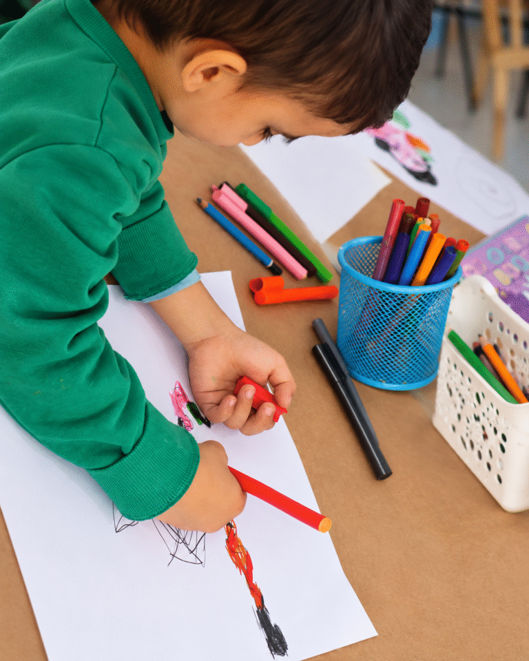 Enfant dessinant avec des feutres pendant un atelier ART PLUS