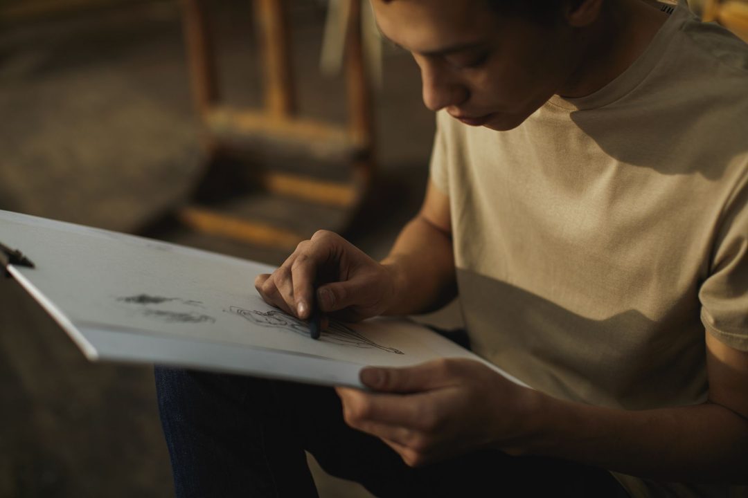 Artiste adulte réalisant une étude au fusain sur papier