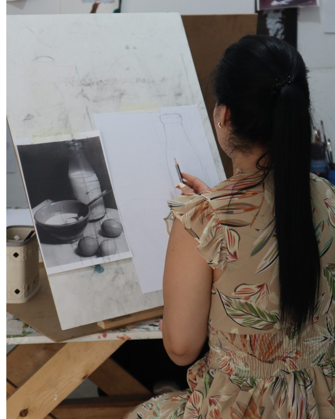 Participante d’ART PLUS construisant une nature morte au crayon