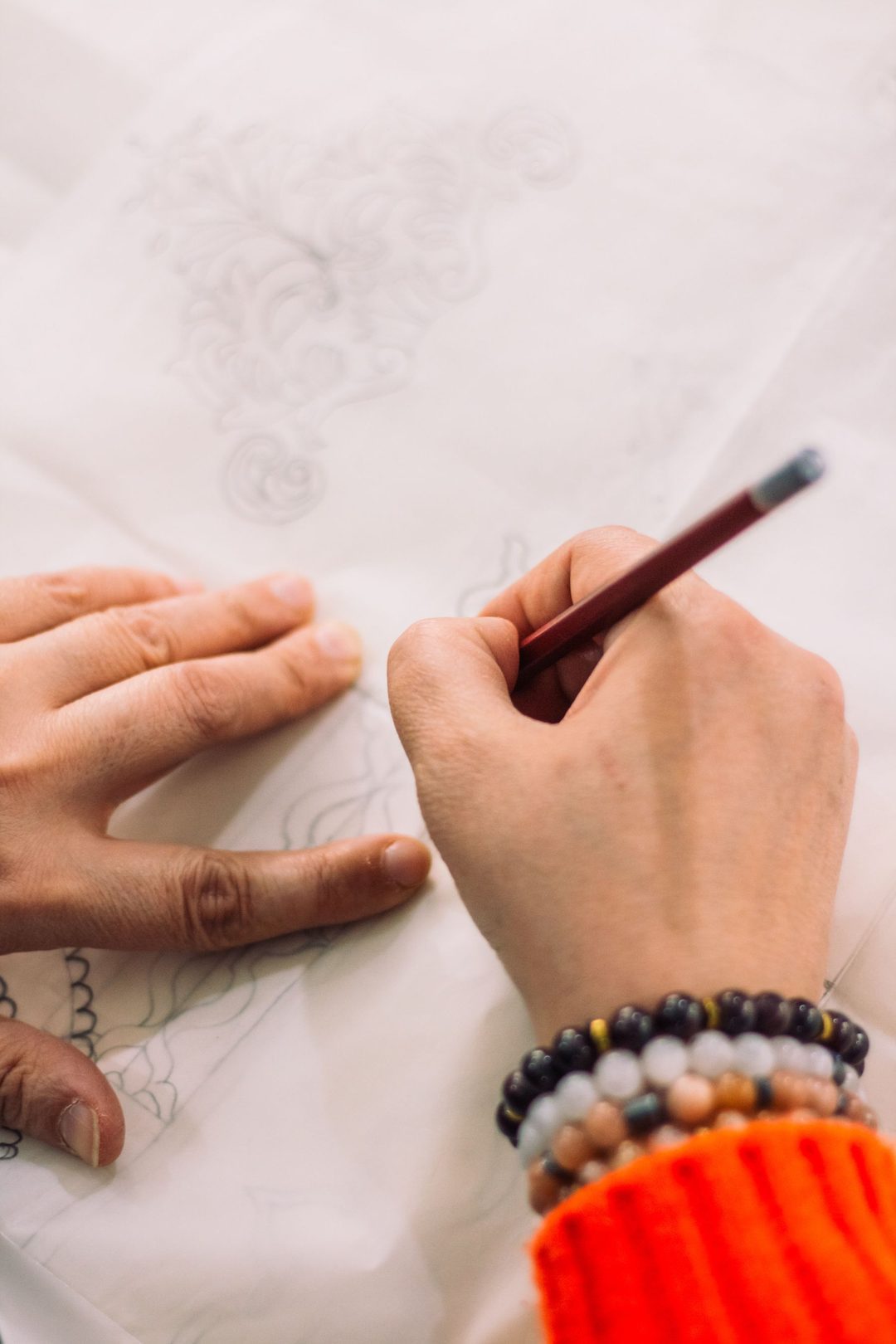 Mains réalisant un dessin détaillé au crayon sur papier