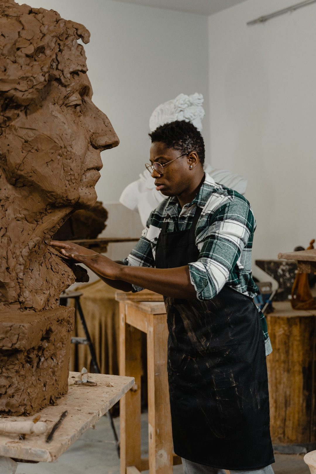 Sculptrice modelant un buste en argile dans un atelier
